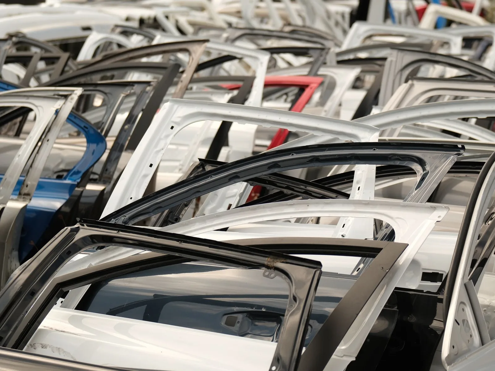 Redovi polovnih automobilskih vrata složenih u skladištu